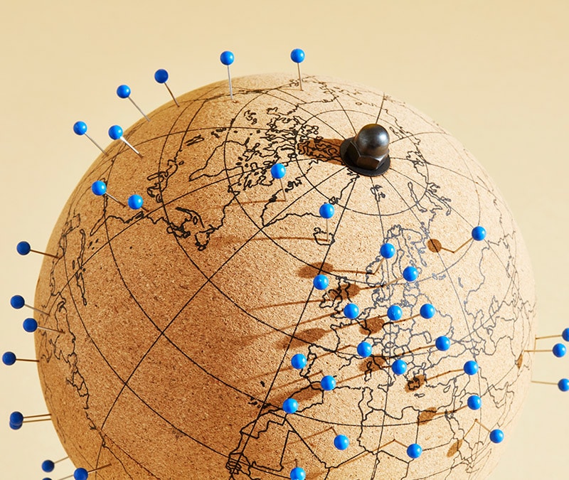 A globe made of cork with blue pins representing VPN locations.