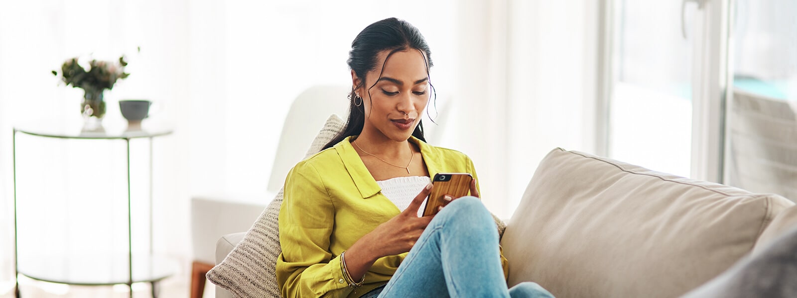 A woman checks the PayPal app on her smartphone.