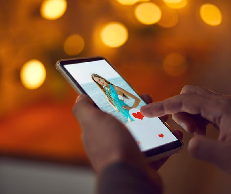 Image of a person “swiping right” on a catfished profile on a dating app.