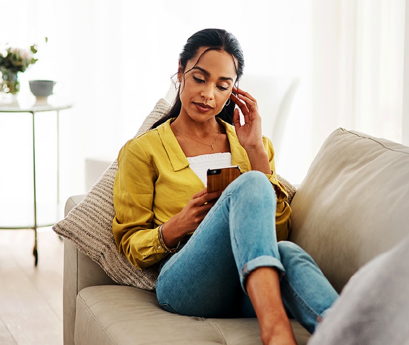 A woman looks at her phone and asks herself, "Has my phone been hacked"?