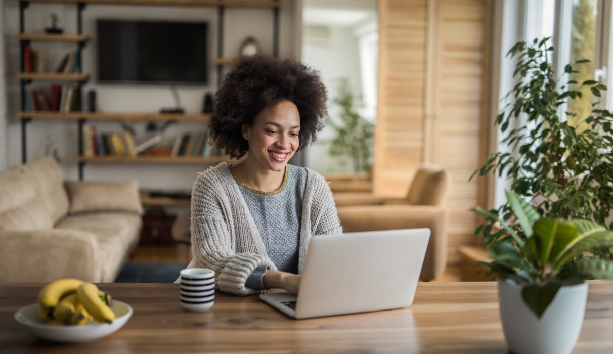 woman looking at laptop smiling.