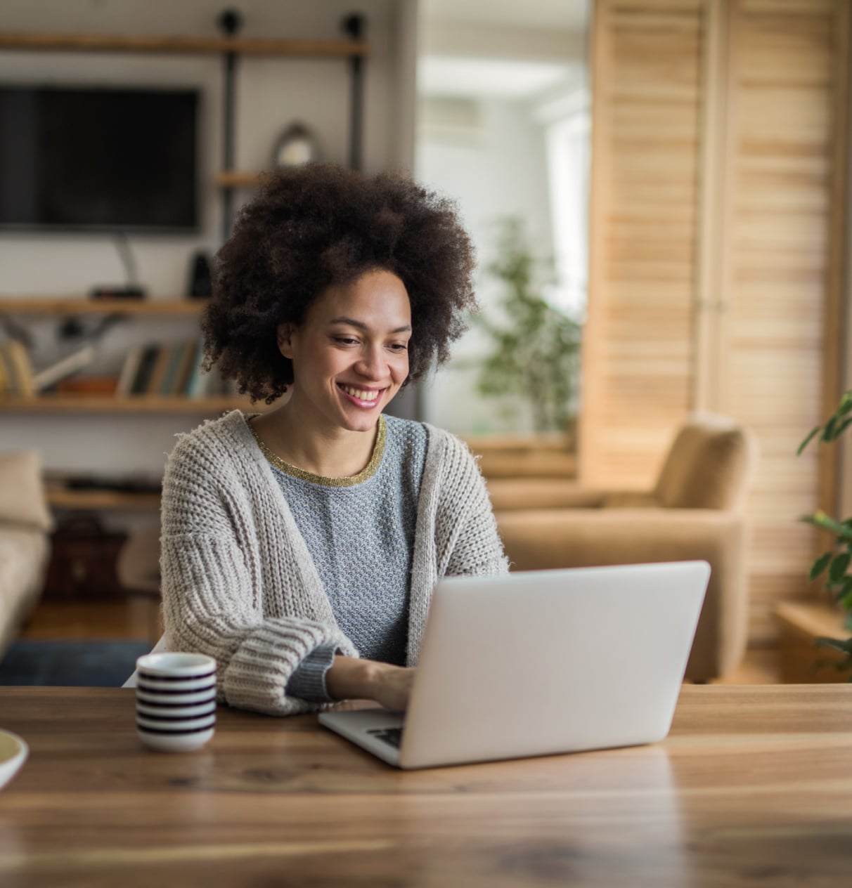 Woman smiling while working on a laptop.