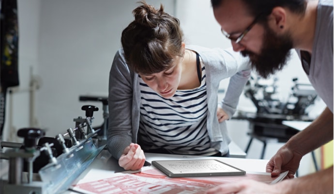 A woman and man looking at a tablet device