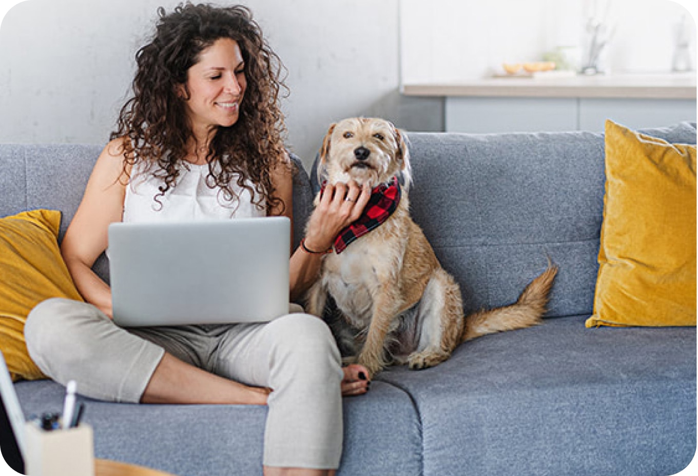 Woman with a dog setting on a couch.